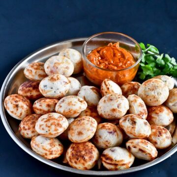 Kuzhi Paniyarams arranged in a plate with garlic chutney and coriander leaves