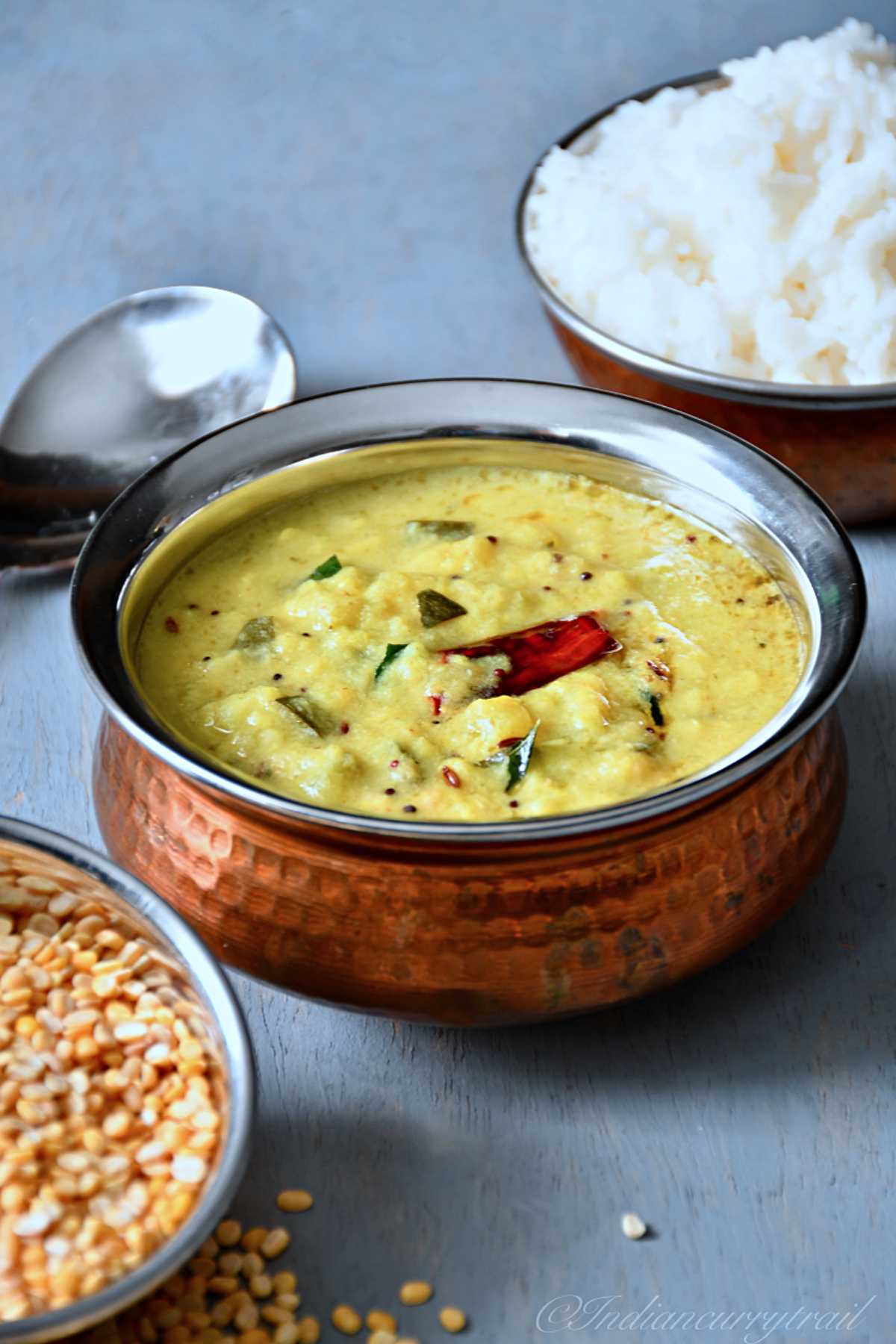 Zucchini Kootu served in a bowl with red chilli on top and rice on side