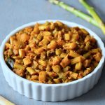 closeup look of asparagus masala served in a bowl seasoned with mustard seeds and curry leaves