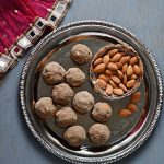 bird eye view of health mix laddu placed on plate with almonds in a bowl