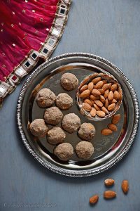 bird eye view of health mix laddu placed on plate with almonds in a bowl