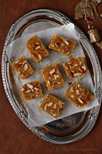 top view of toor dal burfi with nuts on top arranged on a plate