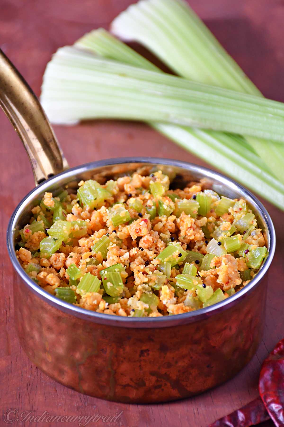 closeup view of celery lentil crumble in a small serving dish with celery sticks kept behind