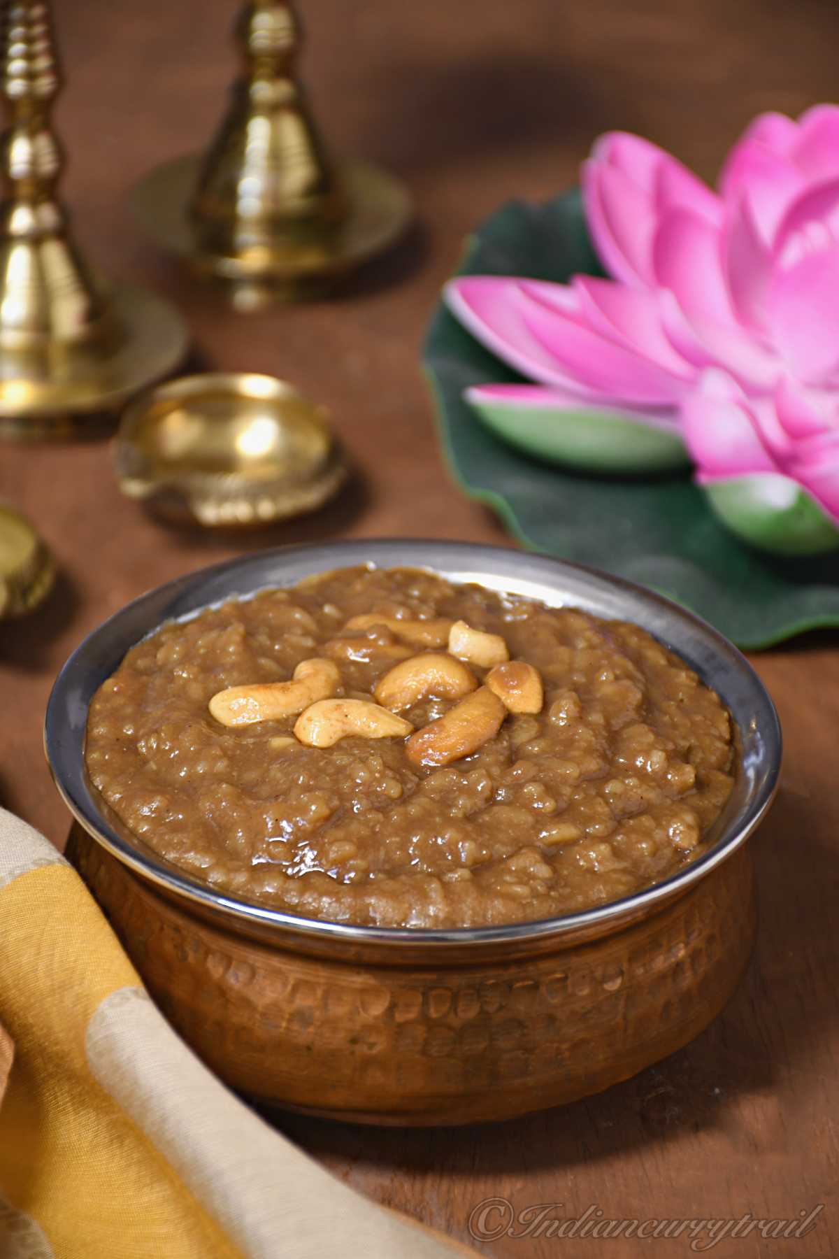 closeup picture of gooey karupatti pongal with fried cashew on top of it