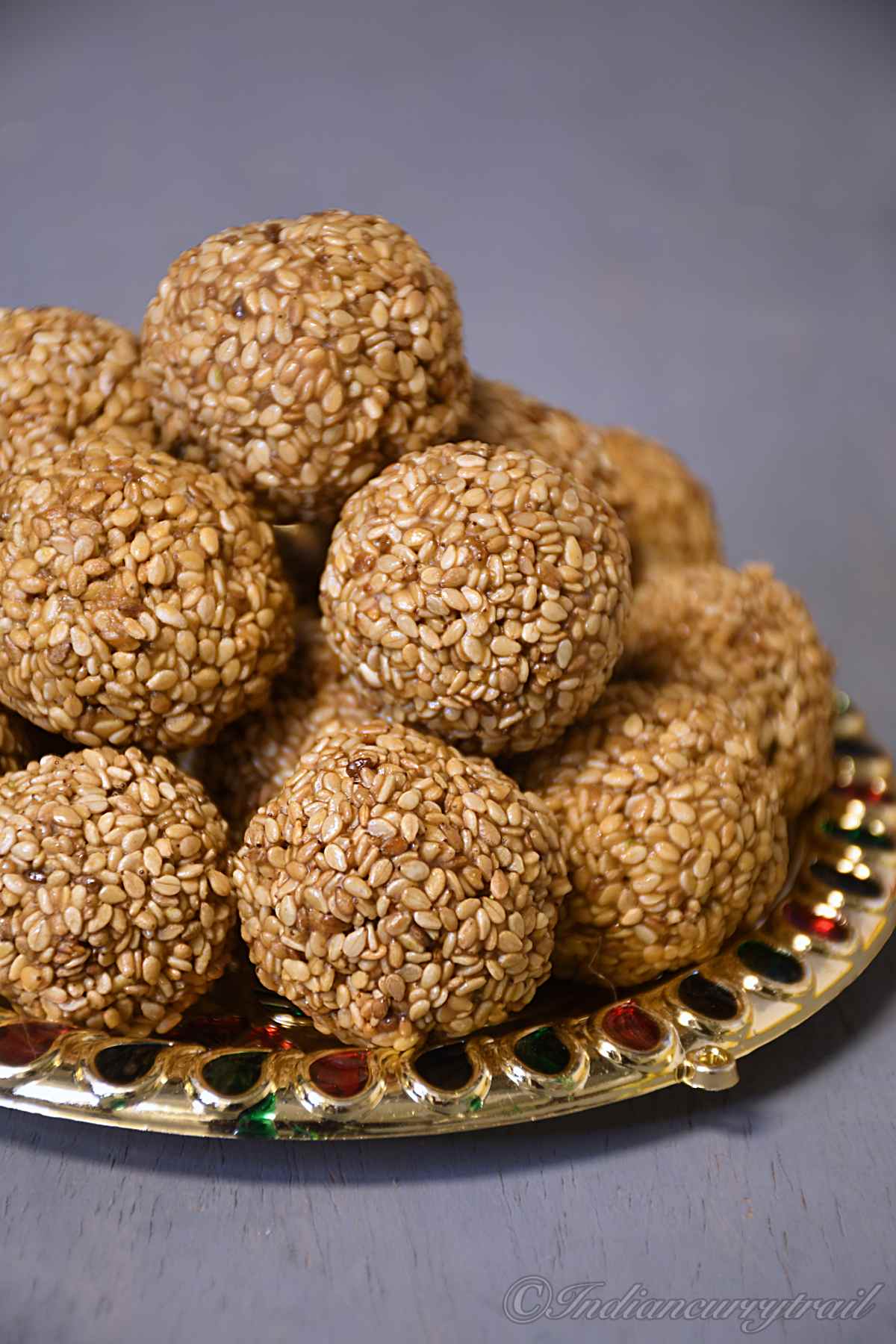 closeup shot of til laddus stacked on a plate